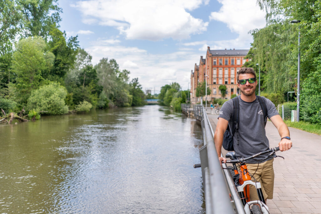 Ein Mann mit Fahrrad direkt an der Fürther Uferpromenade