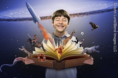 Surprised boy watching colorful characters fly out of open book