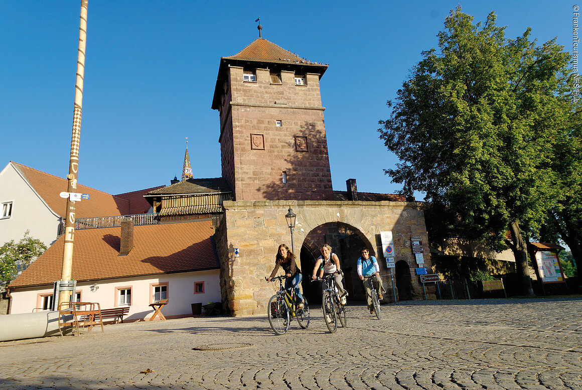 Fränkisches Seenland, Radler in Wolframs-Eschenbach Radfahrer in Wolframs-Eschenbach mit Stadtmauer und Torbogen