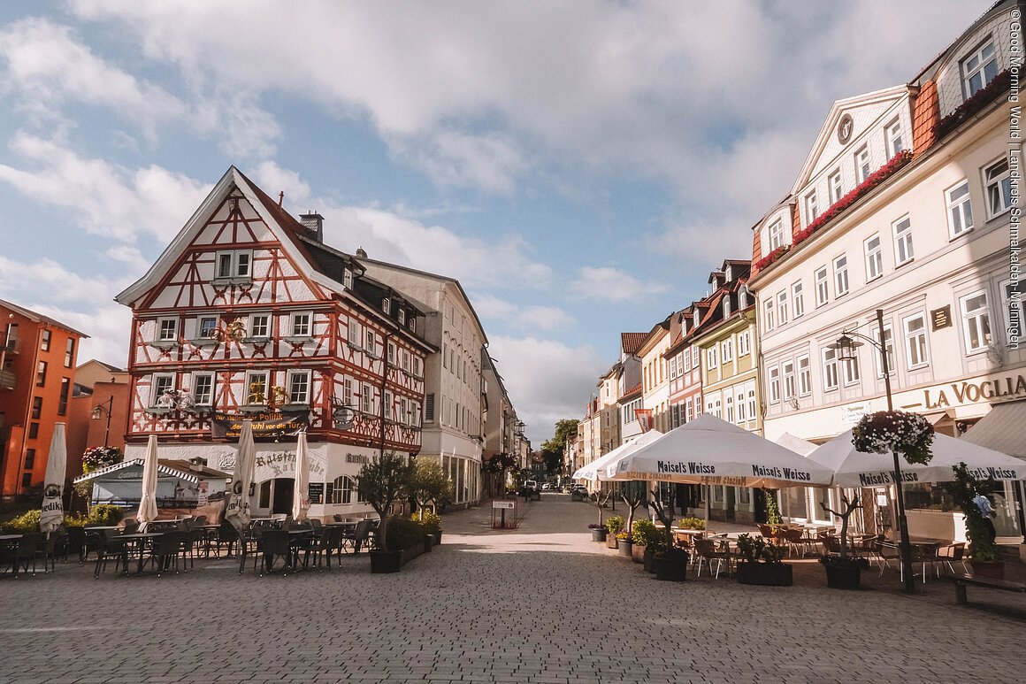 Blick hinein in eine Straße mit Fachwerkäusern und Gastronomie