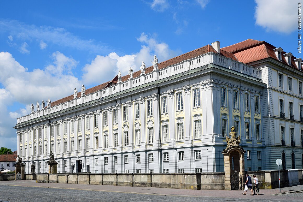 Markgräfliche Residenz (Ansbach, Romantisches Franken) Ein prunkvolles, bläuliches Gebäude im barocken Stil.