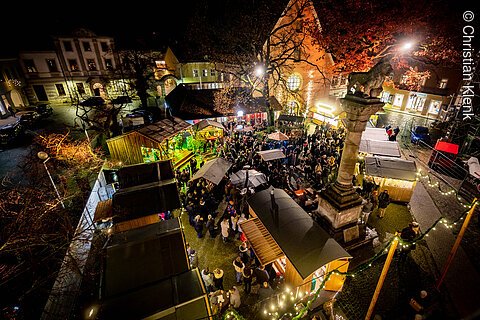 Weihnachtsmarkt Eichstätt (Naturpark Altmühltal) Vogelperspektive auf einen belebten Weihnachtsmarkt bei Nacht mit Ständen und Menschen.