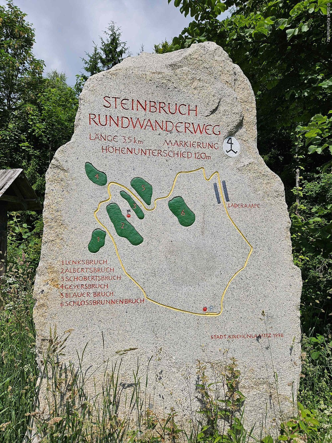 Stein mit Karte des Steinbruch-Rundwanderwegs, Länge 3,5 km, Höhenunterschied 120 m, mit markierten Bruchstellen.