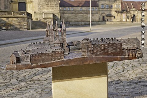 Bronzemodell einer historischen Stadt mit mehreren Gebäuden und Kirchtürmen auf einem Sockel im Freien