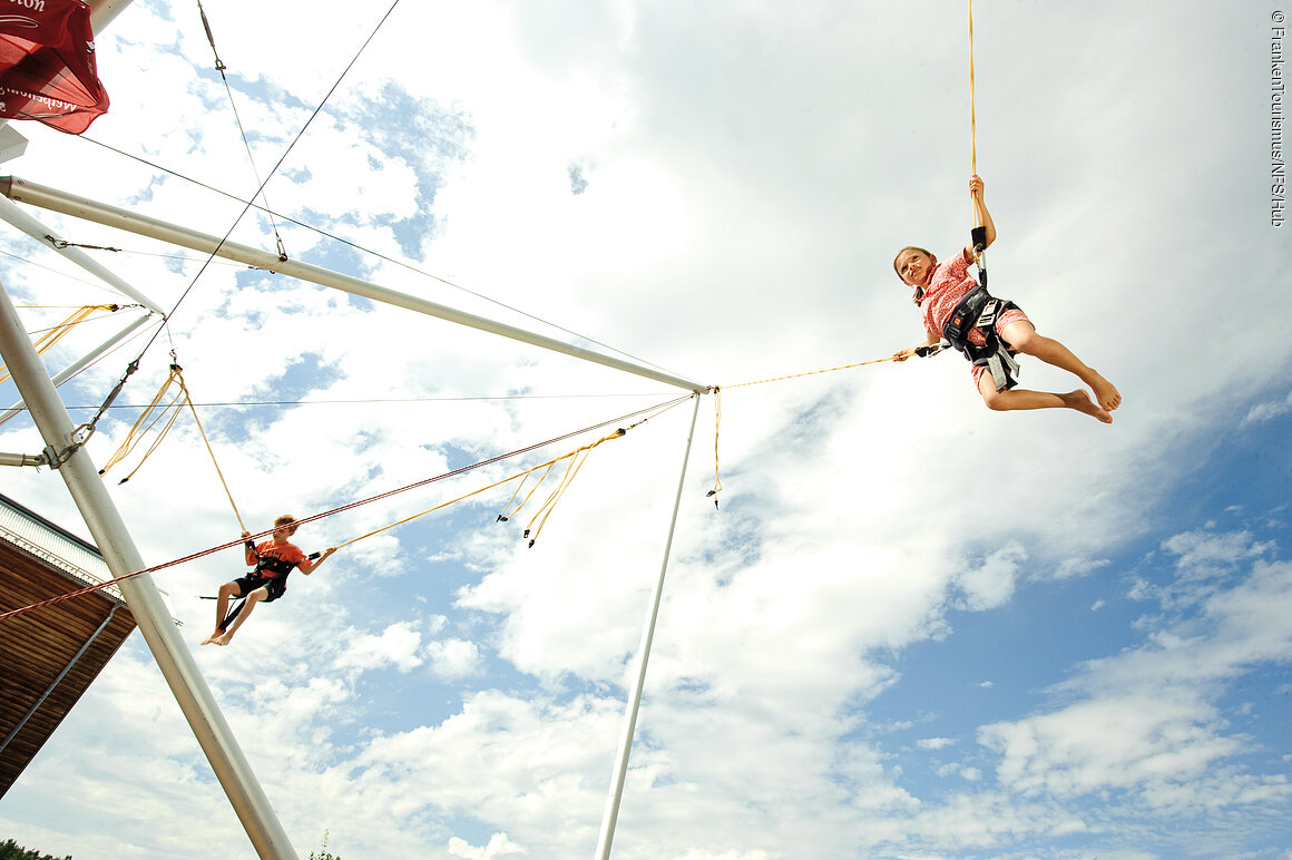 Bungee-Trampolin (Brombachsee, Fränkisches Seenland) Kind beim Trampolinspringen, nahe Brombachsee
