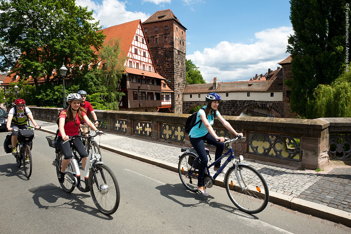 Radler auf der Maxbrücke, Henkersteg im Hintergrund